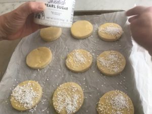 cut shortcakes on a baking sheet being sprinkled with sugar