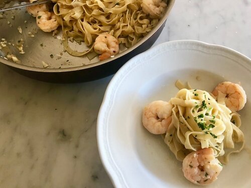 Shrimp scampi with pasta served in a white pasta dish