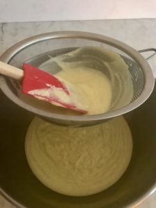 putting the custard mixture through a fine strainer
