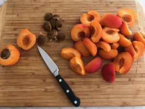 apricots cut in half on a cutting board