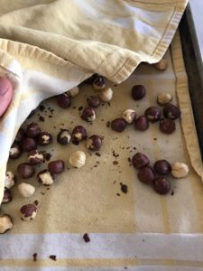 toasted hazelnuts with a kitchen towel over them