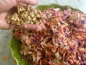 Adding nuts to the bowl of coleslaw