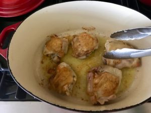seasoned chicken thighs in the bottom of a dutch oven