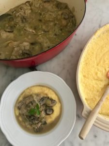 chicken with artichokes and mushrooms plated and served over polenta