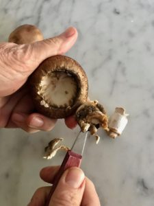 removing the stem of the mushroom using a spoon