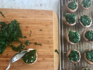 spinach inside the mushrooms on a baking rack