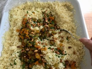 couscous with all ingredients added to it being fluffed with a fork