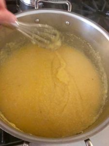 stirring the polenta with a whisk