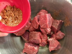 spices in a red bowl with sirloin in a metal bowl
