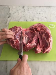 leg of lamb being butterflied and trimmed