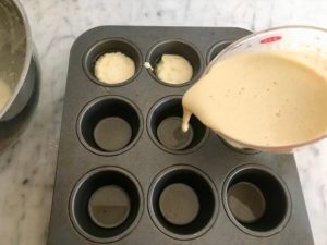 adding pudding mixture to the baking tins