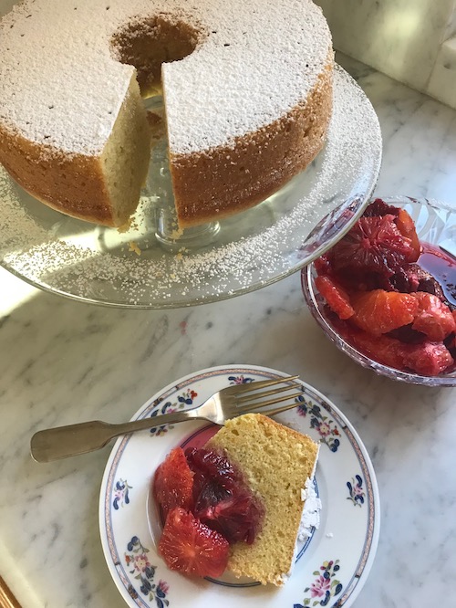 olive oil cake on a platter and a plate with a slice of cake with oranges