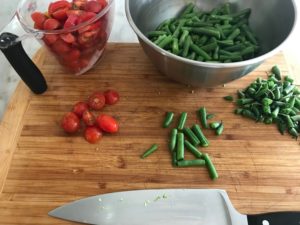 green beans and tomatoes on a cutting board