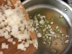 chopped onion being placed into a saute pan