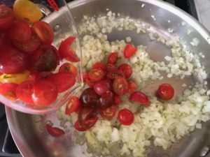 adding the tomatoes to the onions and garlic