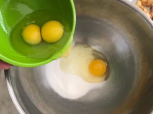 large bowl with sugar and eggs being added to it