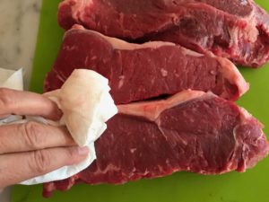 patting the meat dry with a paper towel