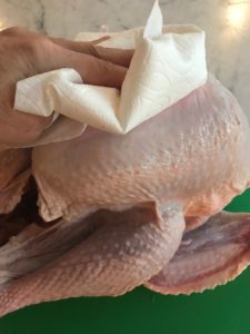 patting turkey dry with a paper towel