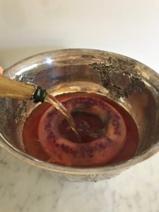 adding champagne to the punch bowl