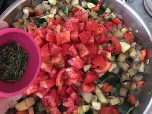 adding tomatoes and thyme to the veggie mixture