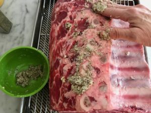 rubbing the roast with spice and herb mixture