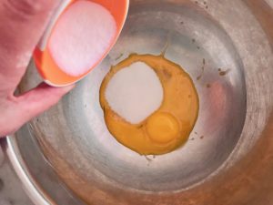 sugar being added to the egg yolks
