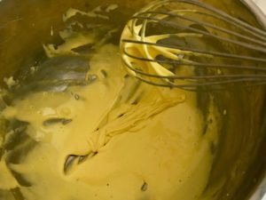 egg yolk mixture being beaten with a whisk