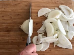 slicing the onion on a cutting board