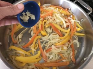 saute pan with onions, peppers, and garlic