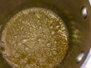 sugar and water mixture boiling in a sauce pot