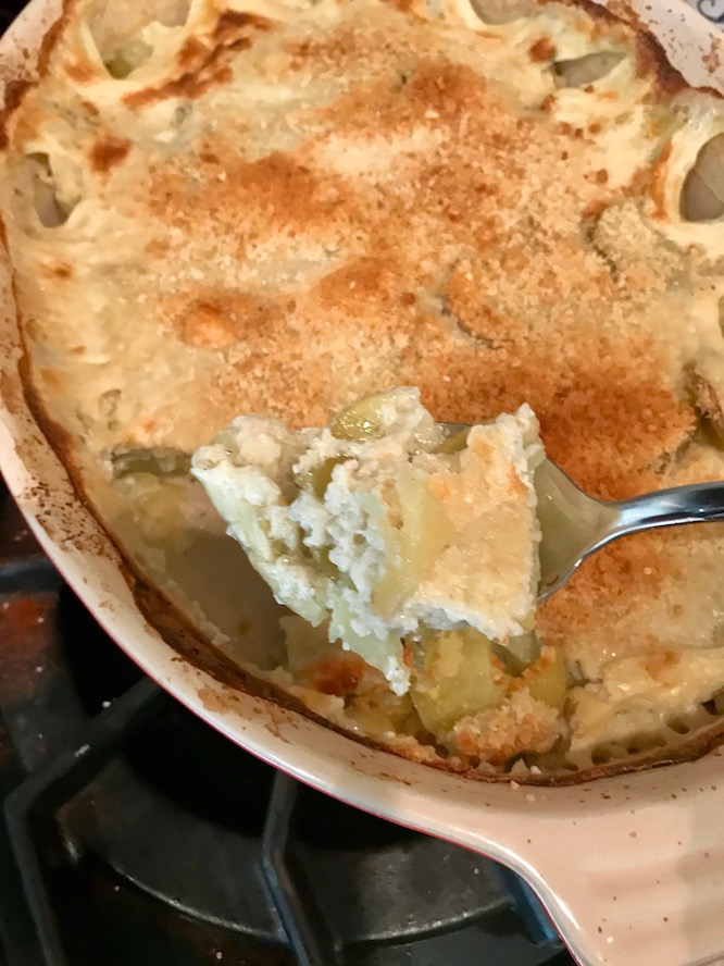 yukon gold potato gratin on a fork and in a serving dish