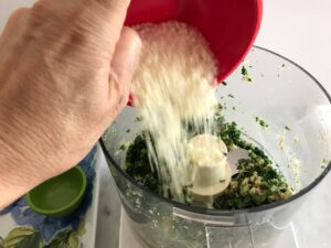 adding the cheese to the food processor