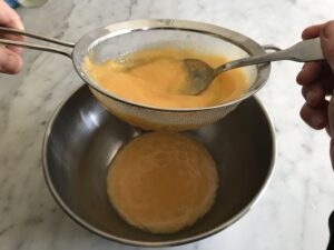 passing the puree through the strainer