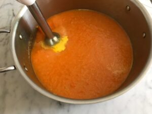 blending the soup with an immersion blender