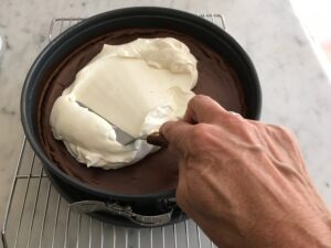 smoothing the topping on to the top of the cheesecake