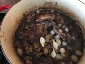 adding the meat and mushrooms back into the pan with the wine
