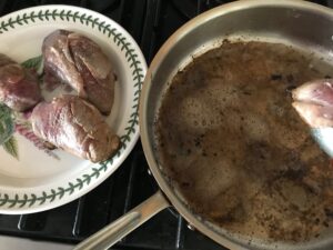 duck breasts on a plate and pouring the fat out of the pan