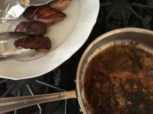 covering the duck breasts with foil on a plate and pouring off the fat from the pan