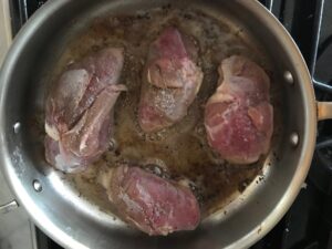 duck breasts skin side down in a frying pan