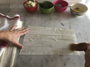 coating the surface of the filo with melted butter