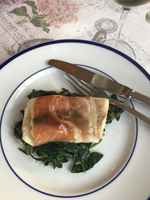 fish saltimbocca and spinach on a plate