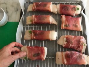 filets wrapped in procuitto on a baking sheet