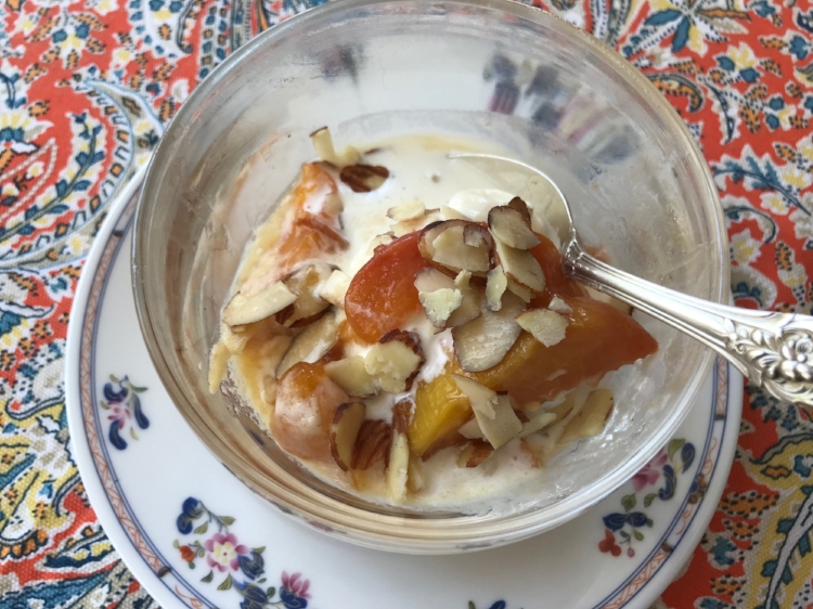 peaches with honey and almonds in a serving bowl
