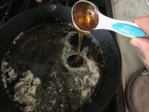 honey being added to butter in a skillet