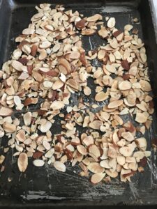 almonds spread out on a baking sheet