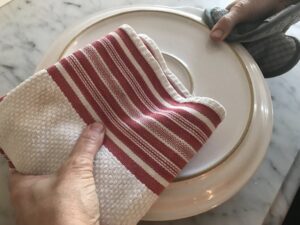 flipping the tart onto a serving dish using a plate and towels