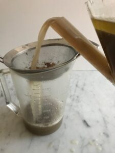 pouring the drippings from the fat separator through a strainer