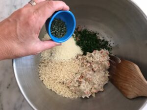 adding the panko and the herbs to the veggie and meat mixture