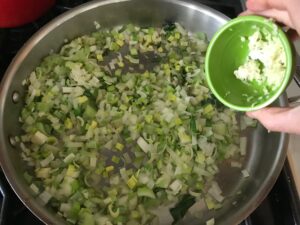 saute pan with onions, leeks, and chard stems
