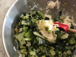 adding the greens to the cheese mixture